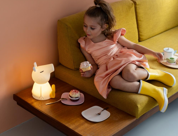 Child eating cake looking at her MR MARIA Peppa Pig First Light Lamp