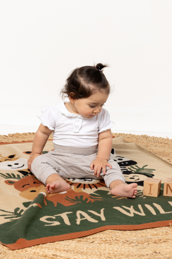 Baby sitting on INDUS DESIGN Stay Wild Baby Blanket