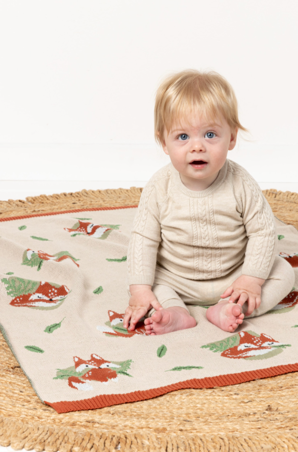 Baby sitting on INDUS DESIGN Freddie Fox Baby Blanket