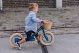 Boy riding a blue balance bike