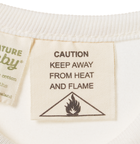 Textile label with 'Caution: Keep Away from Heat and Flame' warning on a white background