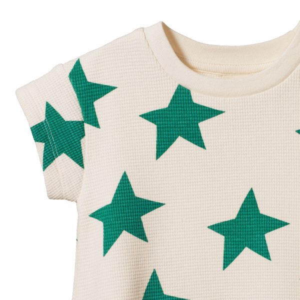 Off-white romper with green star patterns on a white background