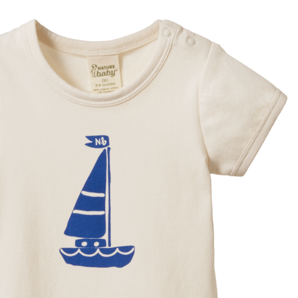 Beige baby onesie with blue sailboat design 