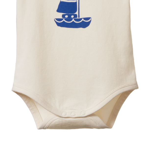 Beige baby onesie with a blue sailboat design on a white background