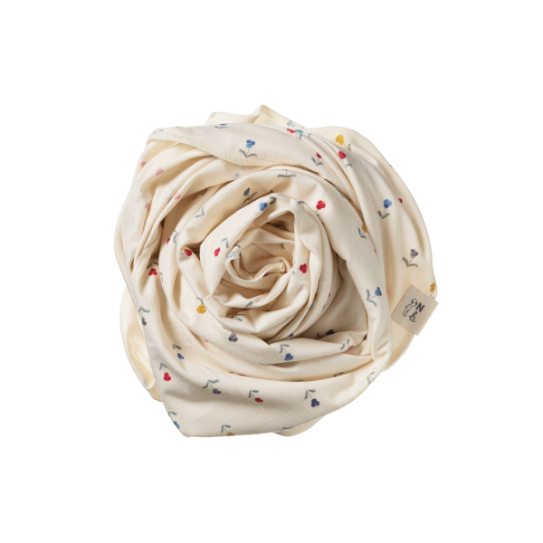 Rolled-up cream-colored wrap with small colorful flowers on a white background