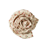 Rolled-up muslin blanket with strawberry pattern on a white background