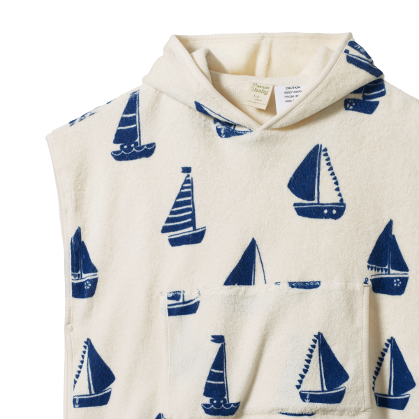 Detail view of hooded towel with blue sailboat pattern on a white background