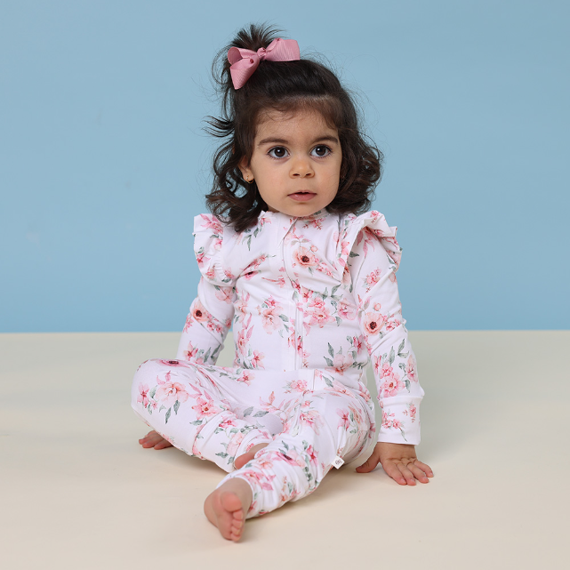Baby wearing a floral onesie against a blue background