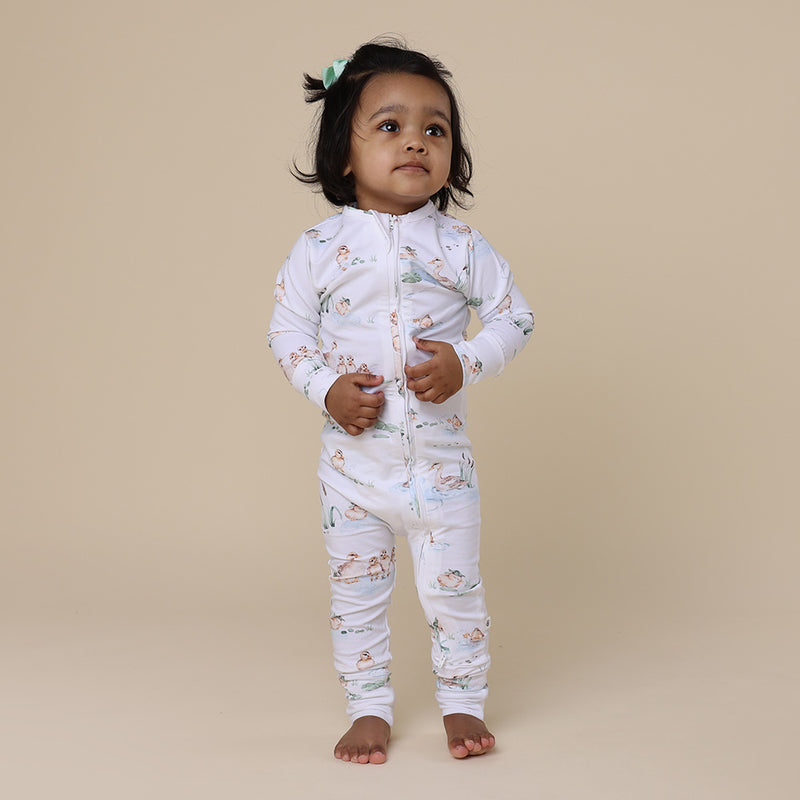 Girl standing wearing SNUGGLE HUNNY Duck Pond Organic Snugglesuit Convertible Romper