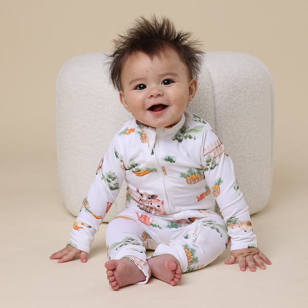 Baby sitting on floor wearing SNUGGLE HUNNY Farm Organic Snugglesuit Convertible Romper