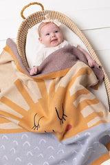 Baby in a bassinet covered with the INDUS DESIGN Sunshine Baby Blanket