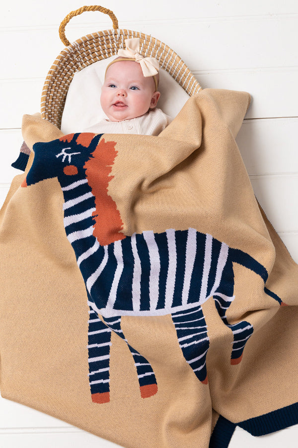 Baby in a bassinet covered with the INDUS DESIGN Zebra Baby Blanket