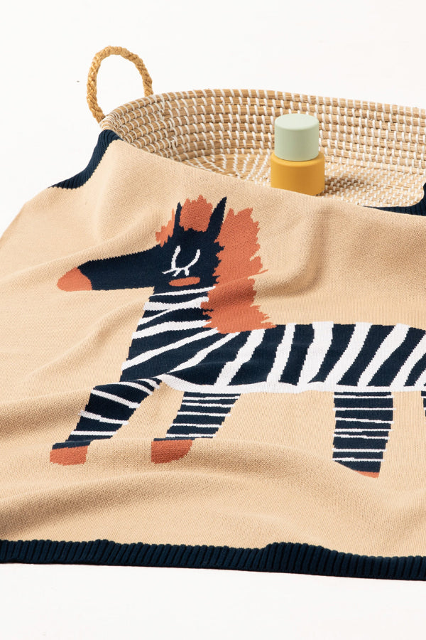 INDUS DESIGN Zebra Baby Blanket draped over a bassinet