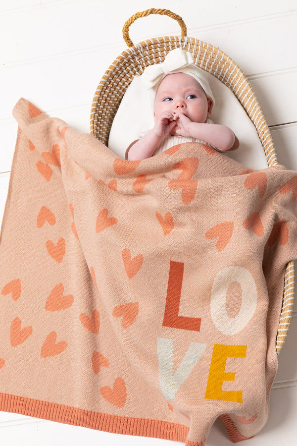 Baby in a bassinet covered with the INDUS DESIGN Love Heart Baby Blanket