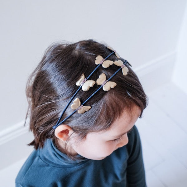 Child wearing the MIMI & LULA Winter Flora - Golden Butterfly Double Alice