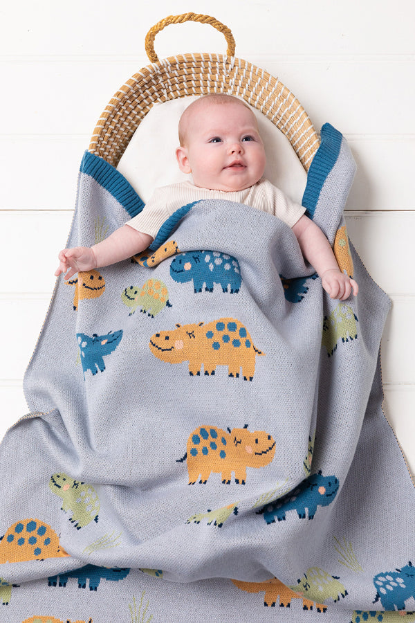 Baby in a bassinet covered with the INDUS DESIGN Henry Hippo Baby Blanket