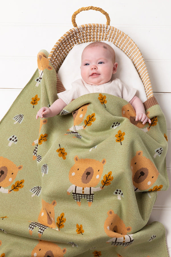 Baby in bassinet covered with the INDUS DESIGN Bruce Bear Baby Blanket