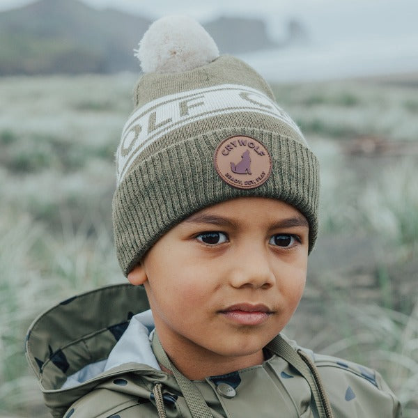 Child outside wearing the CRYWOLF Alpine Beanie - Khaki detail badge view