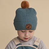 Child wearing the CRYWOLF Pom Pom Beanie - Scout Blue detail view studio image