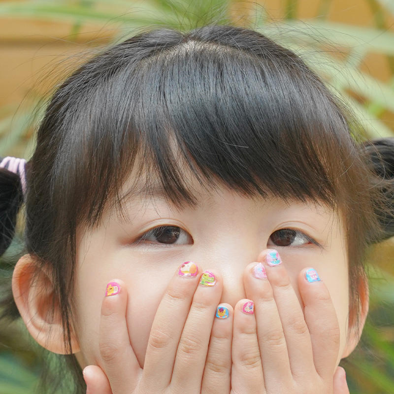 Child wearing TOi nail stickers
