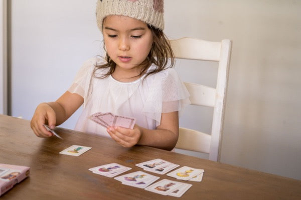 DJECOChild playing Mini Mistigri Tinyly Memory Card Game