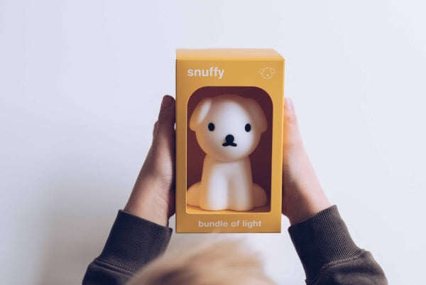 Child holding MR MARIA Snuffy Dog Bundle of Light boxed