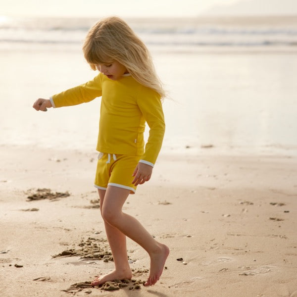 Child wearing NATURE BABY Dandelion Splash Shorts & Splash top