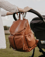 OiOi Faux Leather Nappy Backpack - Tan attached to pram