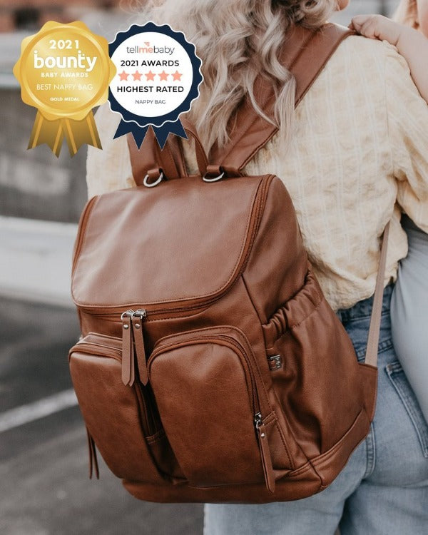 Woman wearing the OiOi Faux Leather Nappy Backpack - Tan