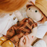 Child holding Pumpkin dinkum doll wearing the OLLI ELLA Travel Togs - Apricot