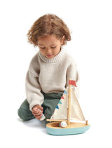 child playing with the TENDER LEAF Sailaway Boat