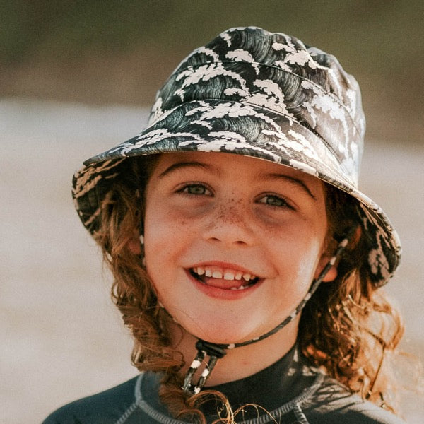 Child wearing the BEDHEAD HATS Kids Classic Swim Bucket Beach Hat - Kahuna 