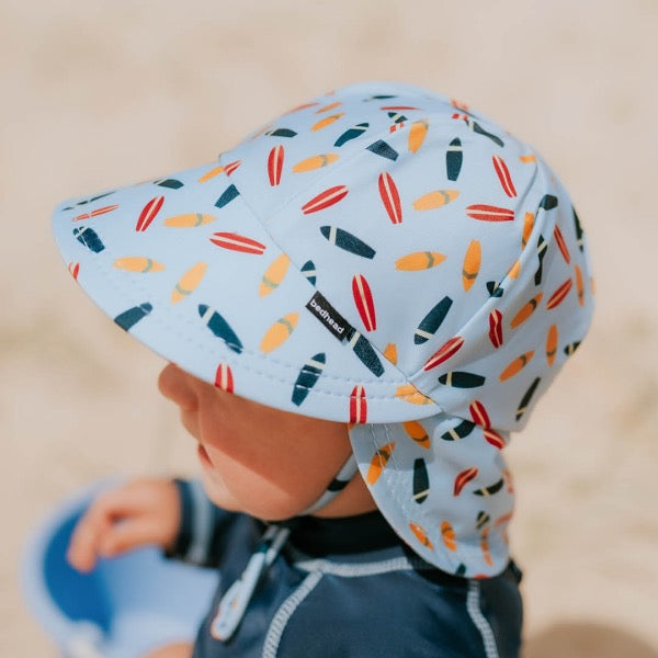 Baby wearing the BEDHEAD HATS Kids Swim Legionnaire Beach Hat - Surfboard side view